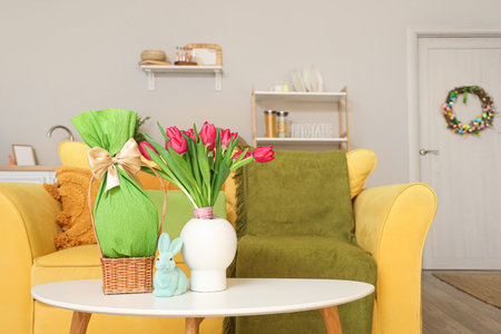 Vase with tulips, Easter rabbit and gift egg on table in kitchen