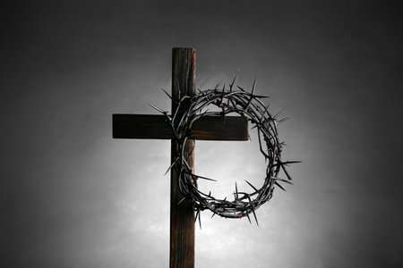 Wooden cross with crown of thorns on gray backgroundの写真素材