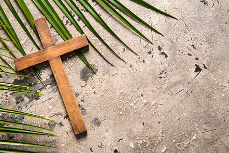 Wooden cross with palm leaves on gray backgroundの写真素材