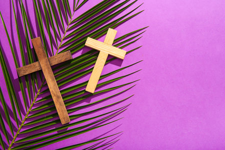 Wooden crosses with palm leaf on purple backgroundの写真素材