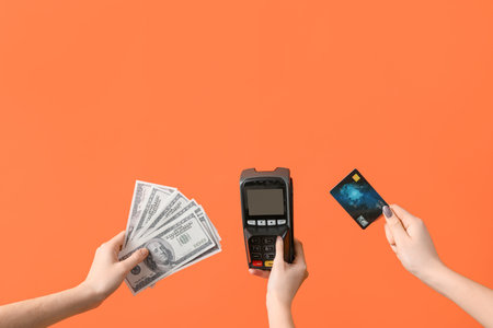 Women with credit card, payment terminal and dollar banknotes on orange background