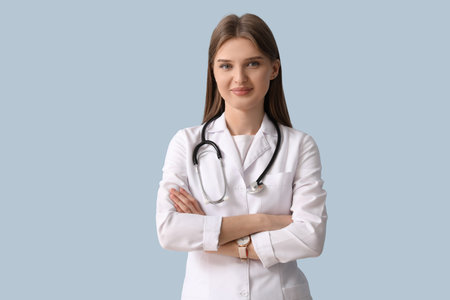 Beautiful young doctor on blue backgroundの写真素材