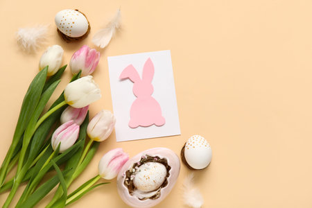 Composition with greeting card, tulips and eggs on beige background. Easter celebration