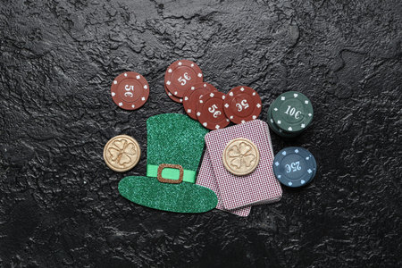 Poker chips, cards and leprechaun's hat on black grunge background. St. Patrick's Day celebration