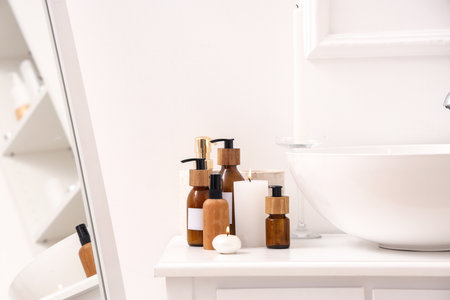 Bottles of skincare products near sink on table in bathroomの写真素材