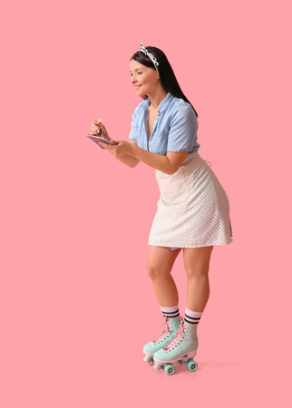 Beautiful young waitress with notebook on roller skates against pink background