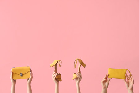 Women with yellow heels and bags on pink backgroundの写真素材