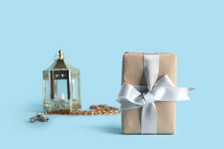 Gift box with Muslim lamp and prayer beads for Ramadan on blue backgroundの写真素材
