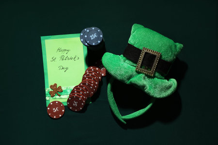 Greeting card with poker chips, leprechaun's hat and clover on dark green background. St. Patrick's...