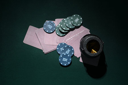 Poker chips, cards and pot with coins on dark green background. St. Patrick's Day celebration