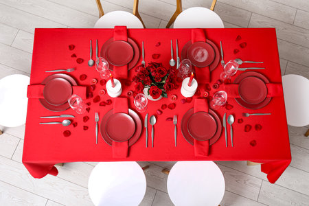Dining table with setting, candles and red roses for Valentine's Day celebrationの写真素材