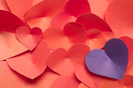 Purple paper heart among red ones, closeup. Valentines Day celebration