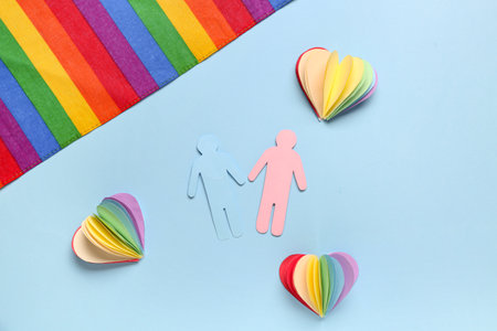 Composition with paper human figures, hearts and rainbow flag on color background. Valentines Day celebrationの写真素材