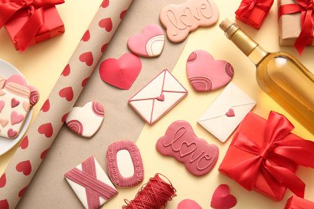 Sweet cookies with wine bottle and gifts on yellow background. Valentine's Day celebrationの写真素材
