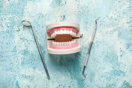 Jaw model and dental tools on grunge blue background. World Dentist Day