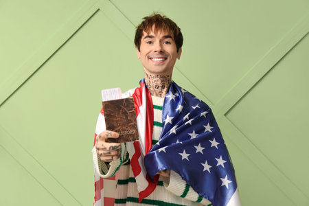 Handsome young man with USA flag and passport on green background. Immigration concept