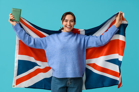 Pretty young woman with UK flag and passport on blue background. Immigration conceptの写真素材