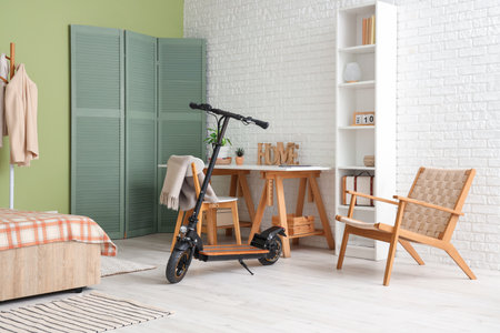 Interior of stylish bedroom with electric scooter and workplaceの写真素材