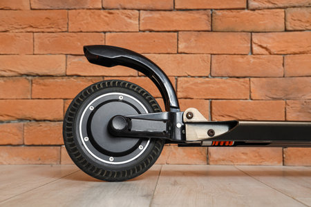 Black modern electric kick scooter near brick wall, closeupの写真素材