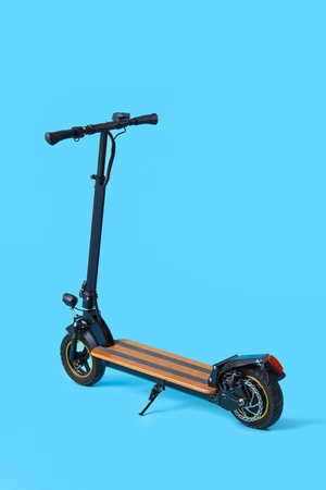 Modern electric kick scooter on blue backgroundの写真素材