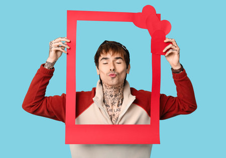 Handsome young man with red frame on blue background. Valentine's day celebration