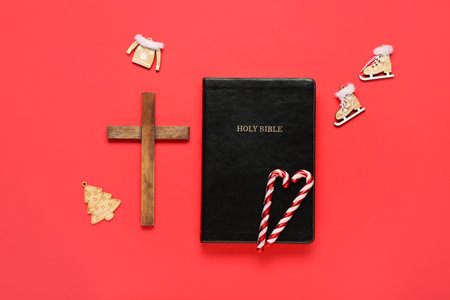 Holy Bible with cross and decorations on red background. Concept of Christmas storyの写真素材