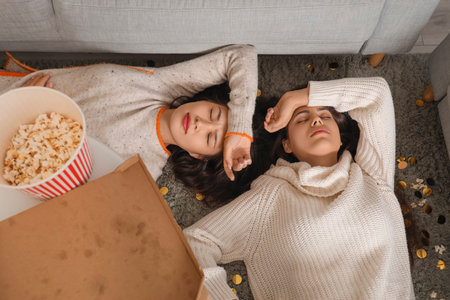 Drunk young women sleeping on floor after New Year party at home, top viewの写真素材