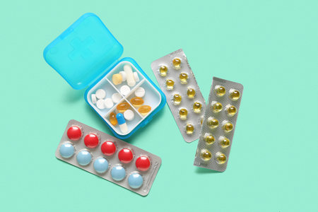 Container with different pills on color background