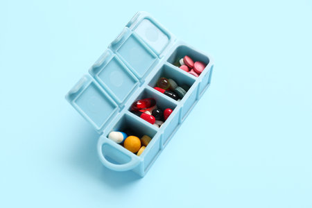 Plastic container with colorful pills on color backgroundの写真素材