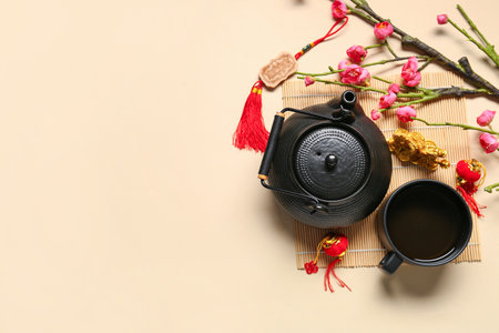 Golden dragon figure with teapot, cup of tea and branch of flowers on beige background. Chinese New Year celebrationの写真素材