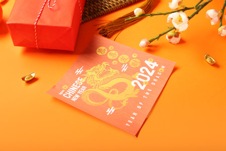 Greeting card, gift box and decor on orange background. Chinese New Year celebrationの写真素材