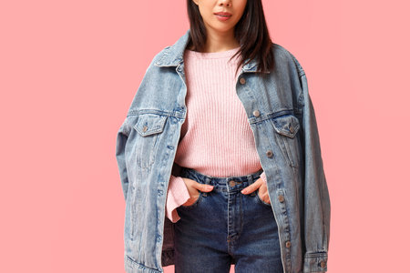 Beautiful young Asian woman in stylish denim clothes on pink background, closeupの写真素材