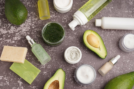 Composition with fresh avocado and different cosmetic products on grunge backgroundの写真素材