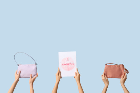 Female hands with festive postcards and handbags on blue background. International Women's Day celebrationの写真素材