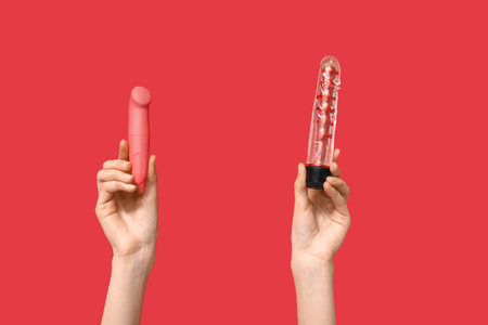 Female hands with vibrators on red backgroundの写真素材