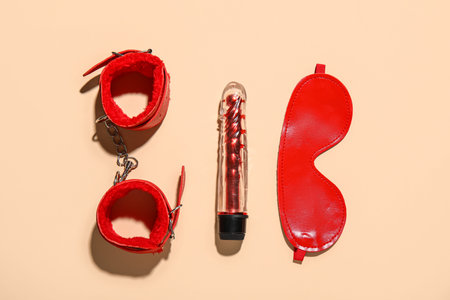 Vibrator with mask and handcuffs from sex shop on yellow backgroundの写真素材