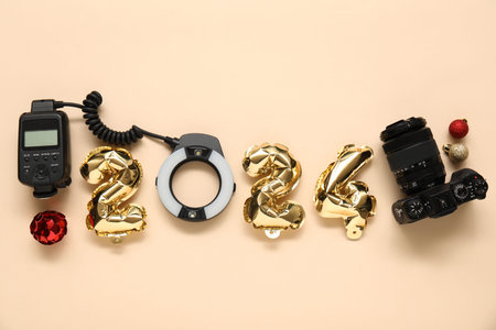 Composition with figure 2024 made of foil balloons, photographer's equipment and Christmas...