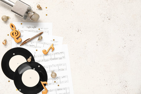 Composition with vinyl disks, music sheets and Christmas decorations on light background