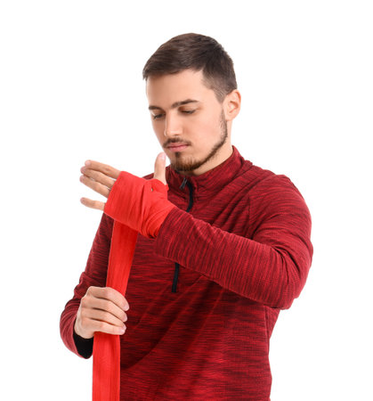 Young man wrapping hands with boxing wraps on white background. Concept of self defenseの写真素材