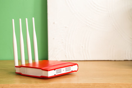 Modern wi-fi router and painting on shelf near green wall, closeupの写真素材