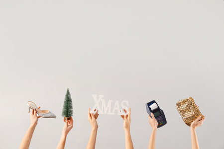Female hands with payment terminal, bag and Christmas decor on white background. New year shopping conceptの写真素材