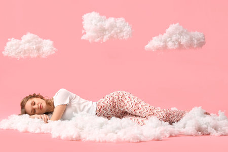 Young woman with white clouds sleeping on pink background
