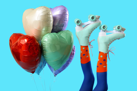 Balloons and legs of woman in roller skates on blue background