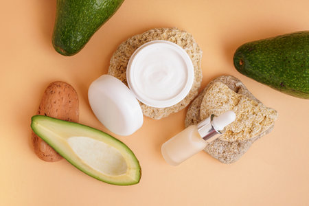 Composition with cosmetic products, stones and avocado on color backgroundの写真素材