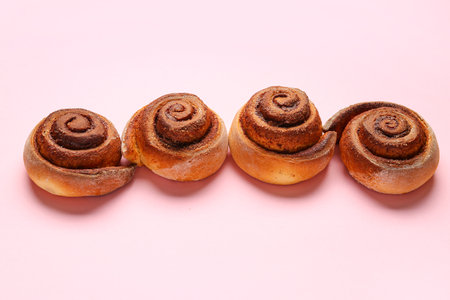 Tasty cinnamon rolls on pink backgroundの写真素材