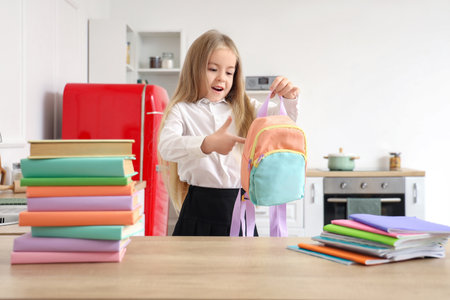 Cute little schoolgirl with small backpack at homeの写真素材