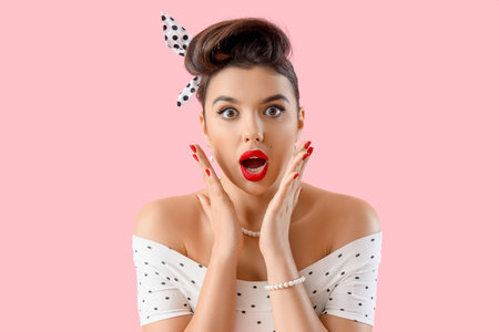 Shocked young pin-up woman on pink background, closeupの写真素材
