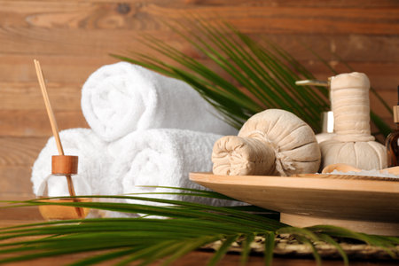 Beautiful spa accessories and palm leaves on wooden background, closeupの写真素材