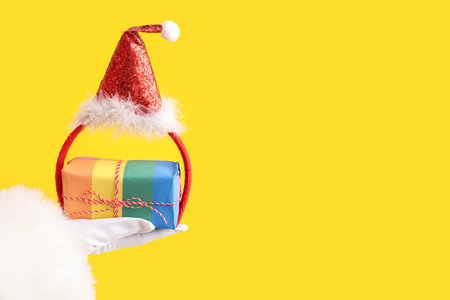Santa Claus with Christmas gift and hat on yellow background. LGBT conceptの写真素材