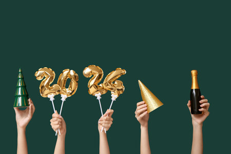Female hands with bottle of champagne, Christmas decorations and figure 2024 made of balloons on green backgroundの写真素材
